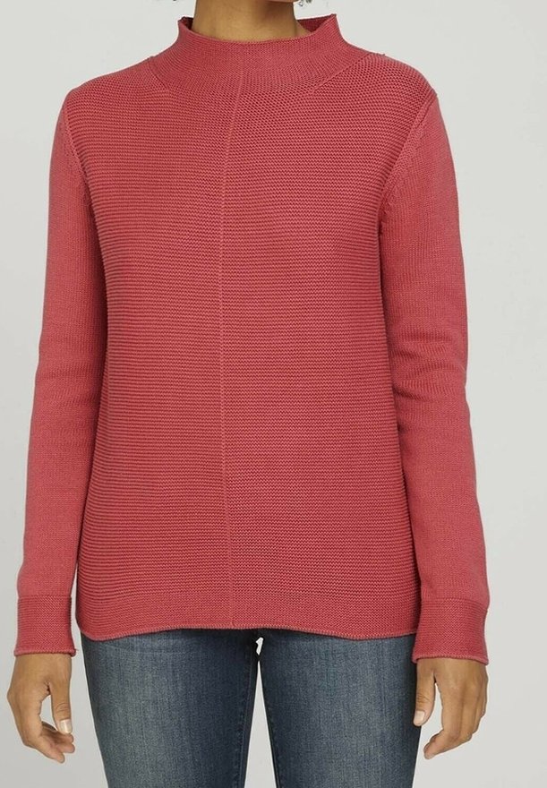 Red knitted sweater with a high neck, textured pattern, long sleeves, and a straight hem. Paired with blue jeans.