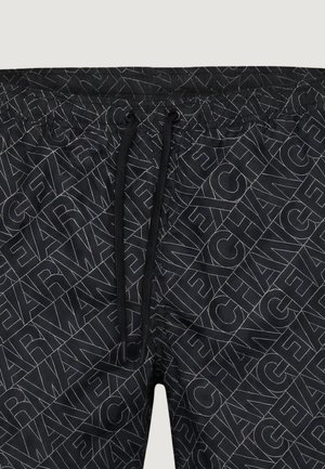 Pantalones cortos de baño negros con un patrón diagonal repetido de texto que dice "ICEBERG" y cordón negro en la cintura.