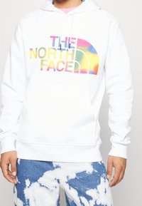 Felpa con cappuccio bianca in misto cotone, con logo "The North Face" multicolore sul davanti. Tasca a marsupio e polsini a costine.