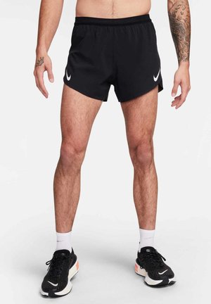Schwarze athletische Shorts aus atmungsaktivem Material, mit einem Netzbund und weißen Nike-Logo-Akzenten an den Seiten.