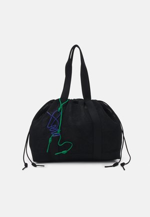 Sac fourre-tout en maille noire avec poignées doubles, fermetures à cordon latérales et cordons décoratifs verts et bleus à l'avant.