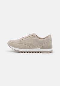 Beige sneakers med strukturerad ovandel, släta skosnörningar, en vadderad krage och en vit mellansula. Har en sål med sågtandad profil för bättre grepp.