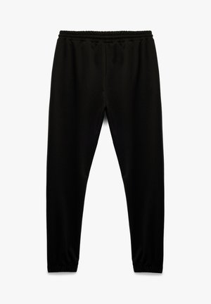Schwarze Sweatpants mit elastischem Bund, schmal zulaufendem Bein und weicher Textur. Keine Muster oder sichtbaren Beschläge.