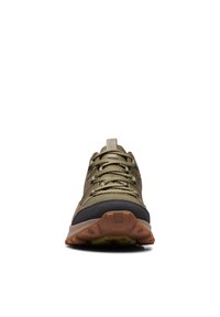 Zapatilla deportiva verde oliva con una puntera negra y una suela texturizada. Presenta un diseño de cordones y detalles de costura reforzada.