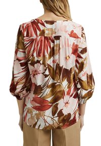 Blusa floreale in tessuto leggero, con motivi di fiori rosa e marroni, dettagli arricciati sul retro e ampie maniche a 3/4.