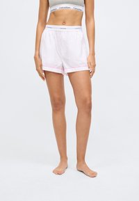 Hvite og rosa stripete shorts med brettet kant, laget av myk stoff, med en Calvin Klein livlinning.