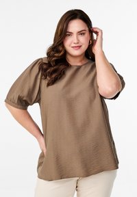 Blusa marrón de mangas cortas con un corte holgado, tela texturizada y escote redondo. Presenta detalles de mangas fruncidas y un acabado suave.