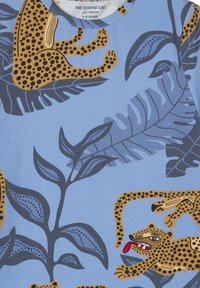 T-shirt in cotone blu con un divertente motivo a leopardo in oro e nero, con accenti di fogliame verde e design classico a girocollo.