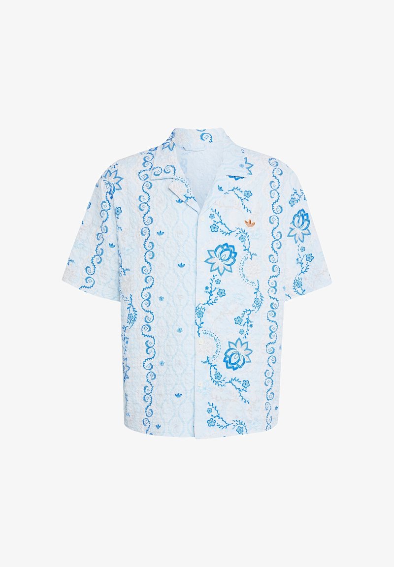 Camisa de manga corta de color azul claro con patrones florales y de remolinos en azul oscuro y un pequeño logo naranja en el pecho izquierdo.