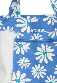 Τσάντα ώμου από μπλε ύφασμα με μεγάλα λευκά μαργαρίτα με πράσινο κέντρο. Περιλαμβάνει τσέπη με φερμουάρ και ανθεκτικούς ιμάντες. Υλικό από υφασμένο βαμβάκι.