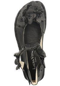 Scarpa in pelle nera con dettagli floreali sulla punta, texture morbida, forma arrotondata e interno imbottito. Logo del marchio visibile all'interno.