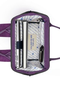 Purple fabric laptop bag with a gray zipper, featuring a lined interior. Contains laptop, notebook, and a small wallet.
