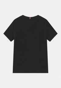 Sort bomulds t-shirt med korte ærmer. Runde halsudskæring, glat tekstur, ingen synlige mønstre, med en lille rød og hvid detalje ved halsen.