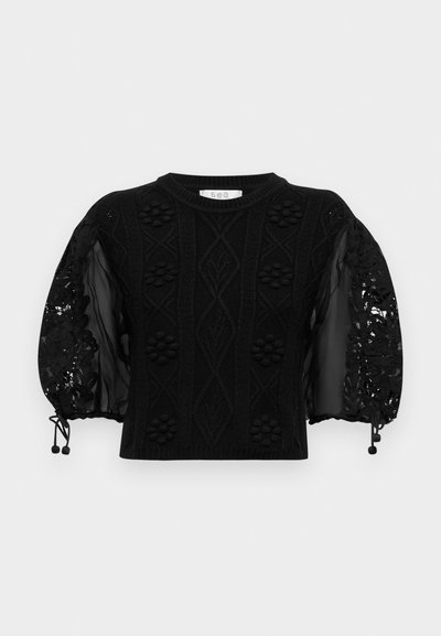 Černý svetr s texturovaným pleteným tělem a průsvitnými krajkovými balónovými rukávy, zdobený květinovými akcenty a nastavovacími šňůrkami na manžetách.