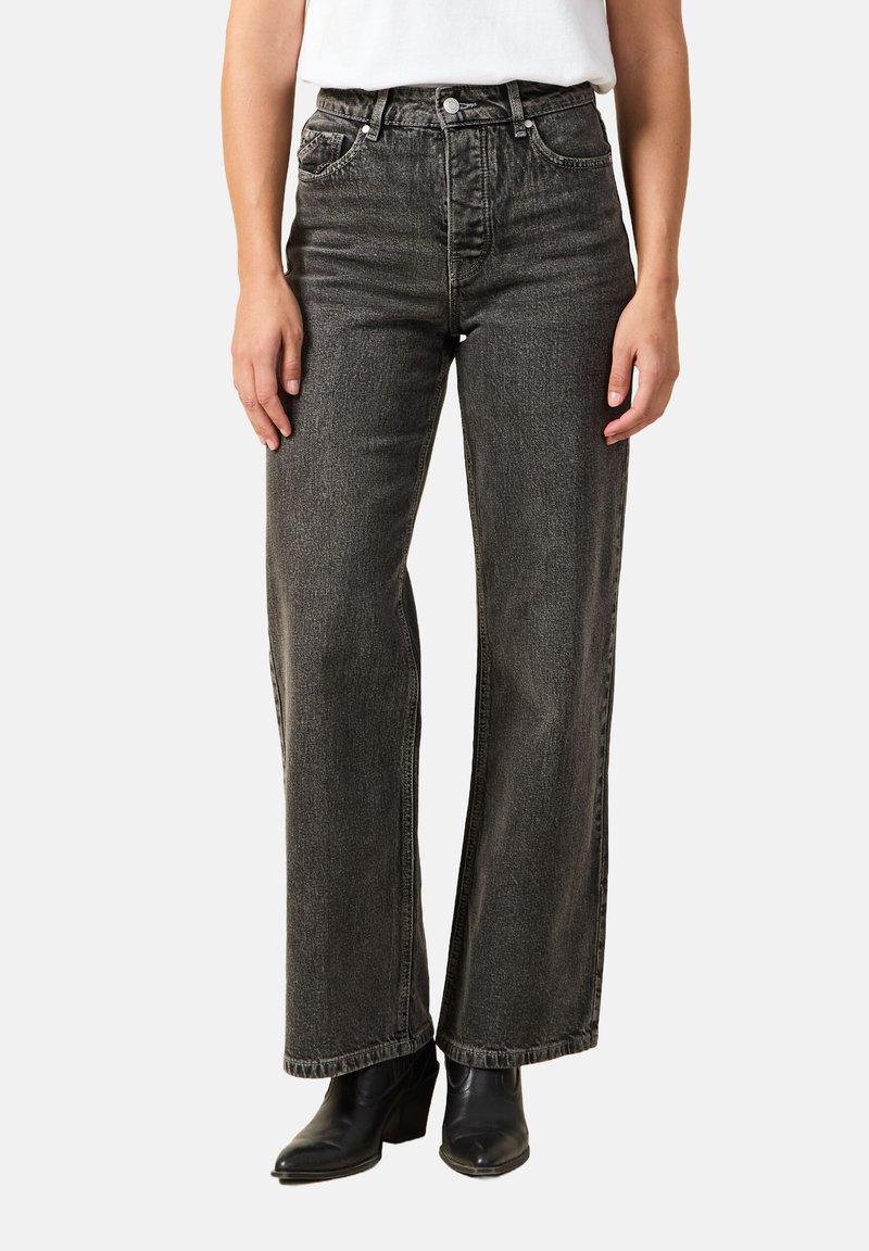 Czarne, wysokie dżinsy z szerokimi nogawkami w wyblakłym denimu o teksturowanym wykończeniu, z kieszeniami z przodu i zamek błyskawiczny.