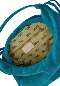 Turquoise suede handtas met een gevoerd interieur, voorzien van een ritszak en accessoires in goudkleur, gedetailleerd met een gebrandmerkt stoffen patroon.