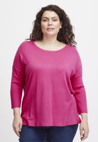 Suéter de punto fucsia con un amplio escote y mangas de tres cuartos. Textura suave, corte relajado y detalles de dobladillo acanalado.