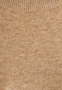 Knit fabric in a warm beige color with a ribbed neckline. The texture is soft and slightly textured, featuring a subtle pattern throughout.