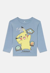 Μπλε πουκάμισο μακρυμάνικο με γραφικό Pikachu και το κείμενο "Εσένα επιλέγω!" καθώς και κονκάρδες Pokémon σε διάφορα χρώματα, από βαμβακερό υλικό.