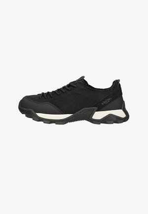 Sneaker nera bassa con suola strutturata, tomaia in tessuto, chiusura con lacci e dettaglio bianco lungo la suola intermedia, mostrata di profilo.