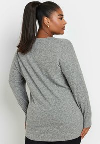 Graues Langarmoberteil aus weichem Strickstoff, mit Rundhalsausschnitt und lockerer Passform, mit einem etwas längeren hinteren Saum.