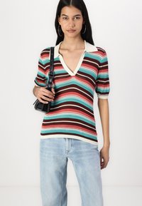 Knit striped pullover with a V-neck, featuring alternating red, brown, blue, and cream stripes. Short sleeves and ribbed texture.