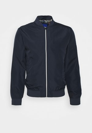 Námořnická bombarďácká bunda vyrobená z lehkého materiálu. Obsahuje stojáček, zipové zapínání vpředu, elastické manžety a elastický pas. Hladký povrch.