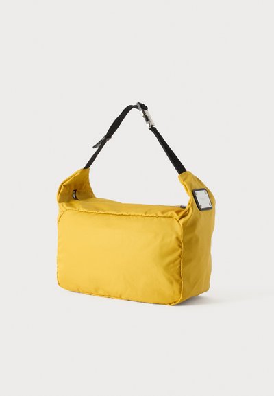 Sac à épaule rectangulaire jaune avec bandoulière noire réglable et petit détail métallique sur un côté, sur fond blanc.