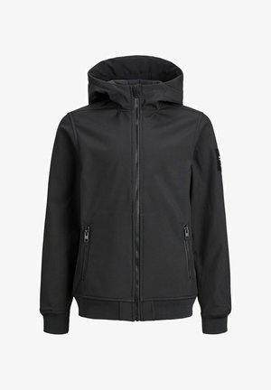 Persona que lleva una sudadera con capucha negra con cremallera, camiseta negra, pantalones cargo vaqueros azul claro y zapatillas negras con cordones y suelas blancas.