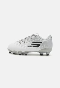 Light gray soccer cleat with textured upper, black accents, lace-up design, and a molded outsole featuring six conical studs for traction.