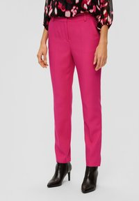 Fuchsia op maat gemaakte broek met een rechte snit, riemlussen en voorzakken, gecombineerd met zwarte hoge enkellaarsjes.