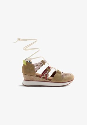 Sandalo beige con zeppa intrecciata, punta in mesh, cinturini in tessuto e lunghi lacci bianchi avvolti sopra la caviglia.