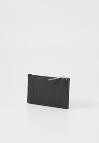 Portefeuille en cuir noir avec une finition texturée, doté d'une fermeture éclair et de plusieurs emplacements pour cartes d'un côté. Design compact et rectangulaire.