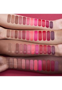 Fargeprøver av leppestift på armer som viser ulike nyanser: nude, rosa, rød og dyp plomme. Mat tekstur, merket 01-12 under hver prøve.