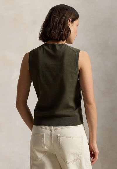 Πράσινο ελιάς αμάνικο τοπ με ριμπ τελείωμα και λεπτομέρειες στους ώμους, σε συνδυασμό με ανοιχτόχρωμο, άνετο παντελόνι με τσέπες στο πίσω μέρος.