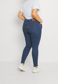 Ciemnoniebieskie rurki z wysokim stanem, wykonane z denimu. Posiadają tylne kieszenie i subtelne przetarcia na mankietach.