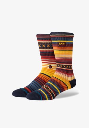 Mehrfarbige Socken mit kräftigen Streifen in Rot, Gelb, Blau und Creme; gewebtes Logo und Muster; gerippter Bund und verstärkte Zehen.