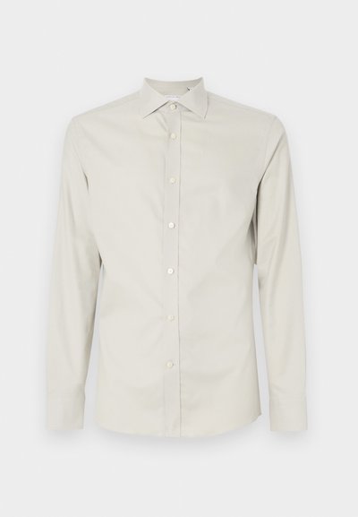 Lys beige, langermet skjorte laget av glat stoff med spiss krage, frontlukking med knapper og uten synlige mønstre eller aksenter.