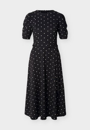 Sort midikjole med hvide polkaprikker, puffede korte ærmer, indsnævret talje med bindebånd og rund halsudskæring.