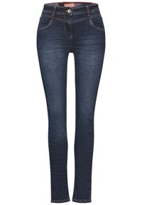 Jeans skinny en denim bleu foncé avec cinq poches, fermeture à bouton à l'avant et détails de couture subtilement contrastés. Texture lisse sur l'ensemble.