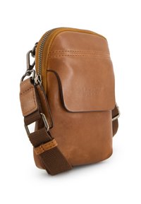 Hnědá kožená crossbody taška se zipovým uzávěrem, přední kapsou a nastavitelným látkovým popruhem; má hladký povrch a embosované logo.
