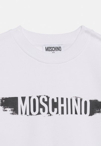 Λευκό T-shirt με ασπρόμαυρο ορθογώνιο σχέδιο βουρτσίσματος και το "MOSCHINO" τυπωμένο με έντονα κεφαλαία γράμματα στο στήθος.