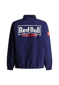 Navyblauw racejack met het 'Red Bull RACING'-logo in wit en rood op de achterkant en een kleine rode rechthoekige patch op de rechtermouw.