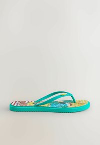 Turkio spalvos šlepetė su spalvingu padu, ant kurio pavaizduotas asmuo mėlyna ir geltona spalvomis, bei rupaus rašto tekstūruotas apatinis padas.