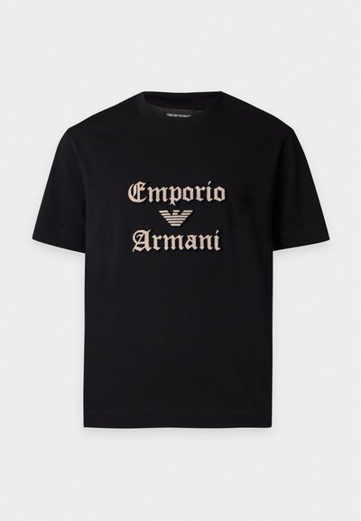 Μαύρο κοντομάνικο t-shirt με μπεζ κείμενο "Emporio Armani" και λογότυπο αετού κεντημένο στο κέντρο μπροστά.