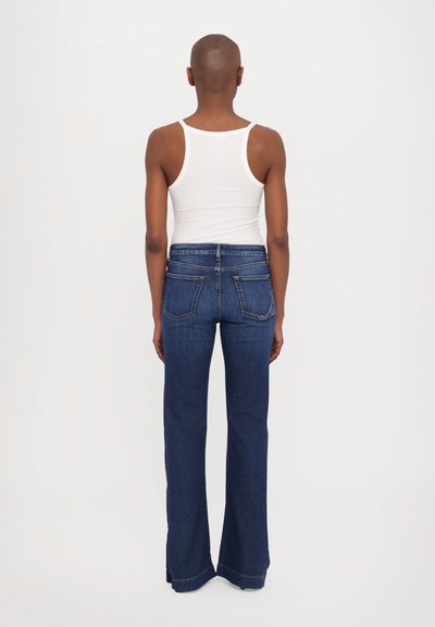 Donkerblauwe flared jeans van denim, met een middelhoge taille, vijf zakken en zichtbare stiksels. Achteraanzicht weergegeven.