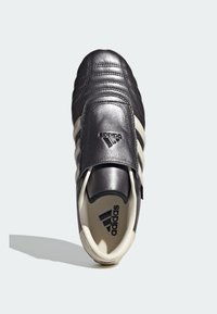 Zwarte leren schoen met een ronde neus, voorzien van drie witte strepen, een gegraveerd logo en een gladde bovenkant.