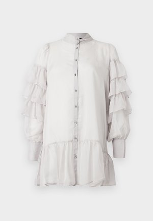 Blusa grigio chiaro con maniche trasparenti arricciate, colletto alla mandarino, chiusura con bottoni sul davanti e orlo a strati. Texture liscia con finitura morbida.