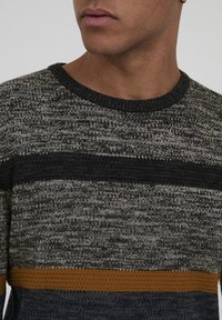 Maglione a righe in nero, grigio e oro con scollatura tonda e tessuto testurizzato. Presenta bande orizzontali di colore alternato.