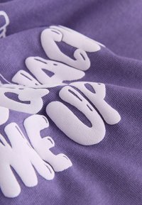 Purple fabric with a soft texture, featuring white text that reads, "WAKING ME UP," in a bold, playful font.